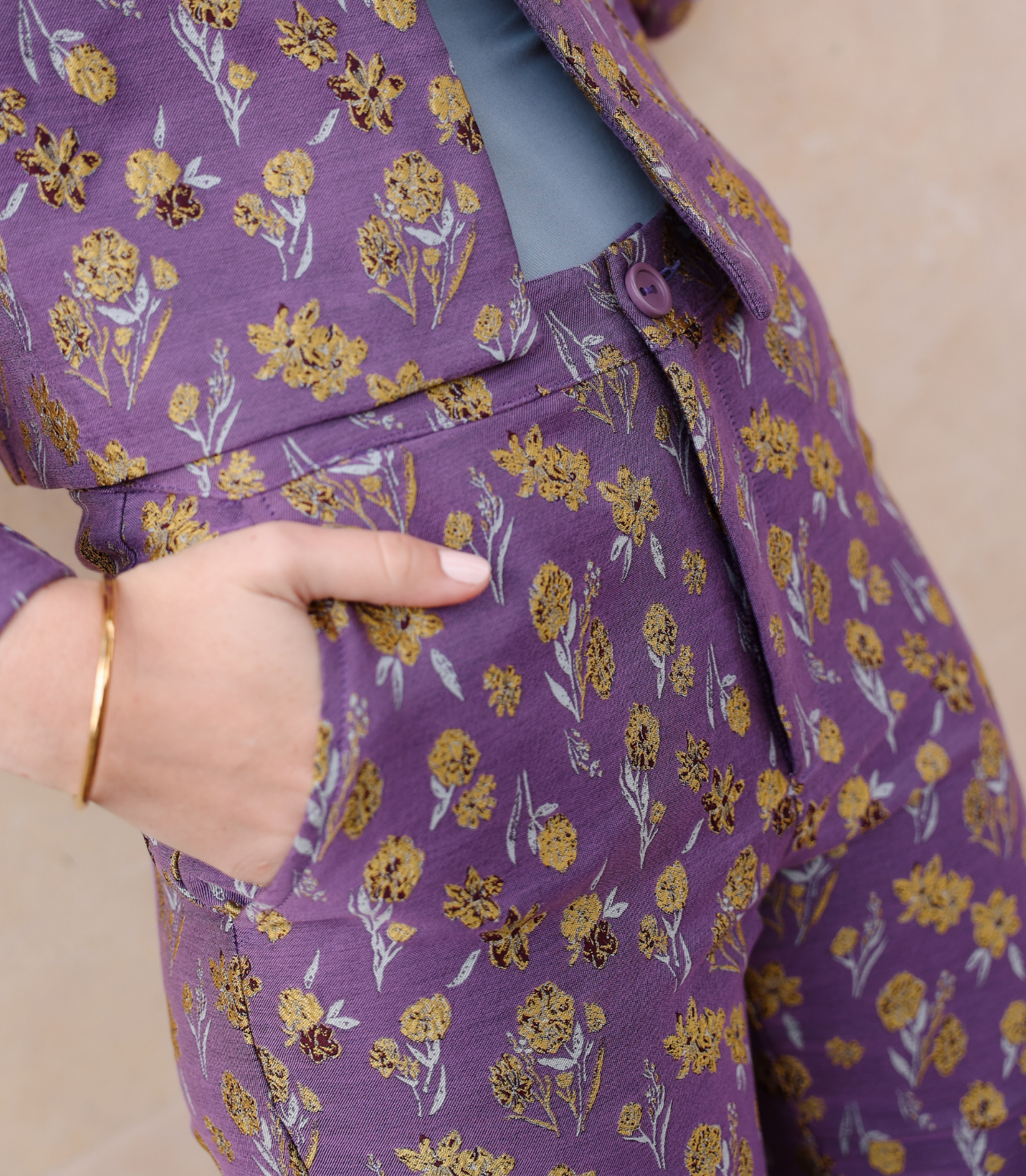 Close-up of the Harper trousers showing the intricate woven goldenberry floral texture and functional side pockets on lilac jacquard fabric.